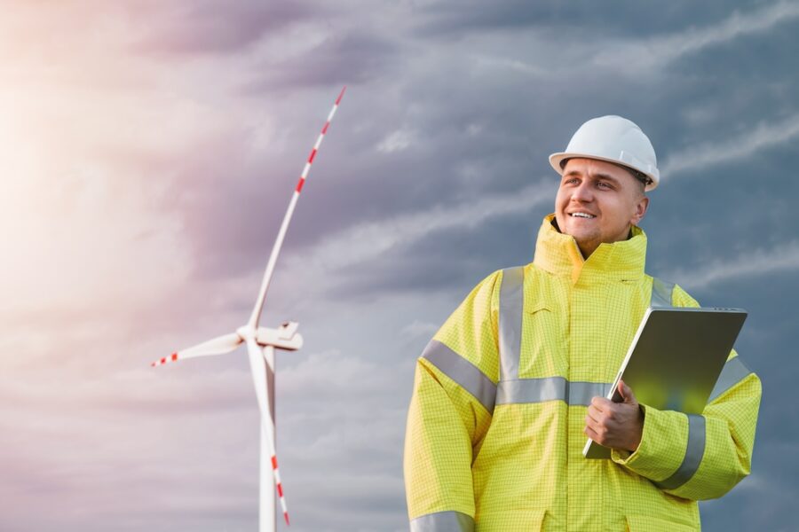 offshore energies worker on the job below a wind turbine